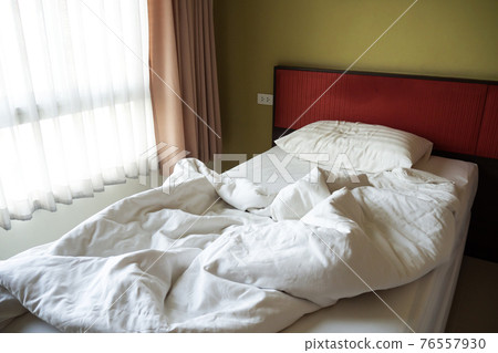 Messy bed. Single messy bed with morning light from window.  76557930