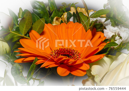 A close-up picture of a bouquet of funeral flowers. White, yellow and orange flowers with green leaves 76559444
