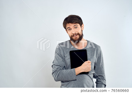 emotional man holding tablet technology communication internet work light background emotional man holding tablet technology communication internet work light background 76560660