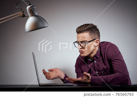 businessman in glasses and a shirt sits at a table with open laptops Coffee Space mobile phone businessman in glasses and a shirt sits at a table with open laptops Coffee Space mobile phone 76560793