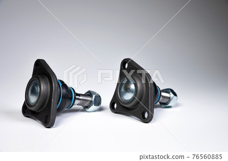 A set of two ball joints of the front suspension of a passenger car on a gray background. Service and new parts A set of two ball joints of the front suspension of a passenger car on a gray background. Service and new parts 76560885