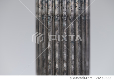 Close-up thread and spline joint of the shaft of the CV joint on a gray background. Macro soft focus 76560888