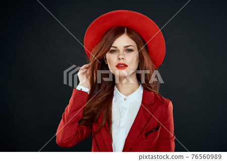 Pretty woman with red lips hat on her head jacket elegant style charm dark isolated background Pretty woman with red lips hat on her head jacket elegant style charm dark isolated background 76560989