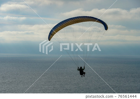 Man doing sport, Para-glider in the clouded sky. 76561444