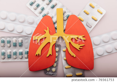 Treat lung diseases. Organ and pills on pink background top view Treat lung diseases. Organ and pills on pink background top view 76561753