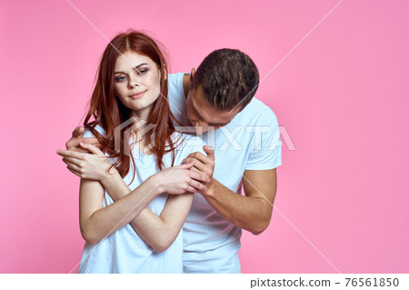 enamored man and woman hugging each other on a pink background cropped with Copy Space family portrait enamored man and woman hugging each other on a pink background cropped with Copy Space family portrait 76561850
