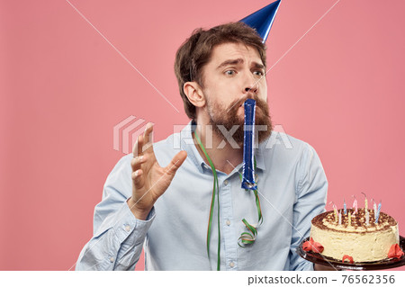 bearded man with cake on pink background emotions cropped view 76562356