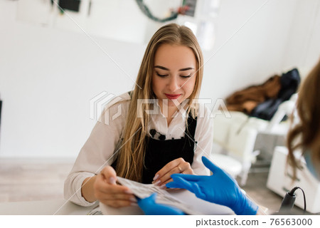 Manicure and pedicure salon, covid-19 and social distance. Master in rubber gloves and woman client Manicure and pedicure salon, covid-19 and social distance. Master in rubber gloves and woman client 76563000