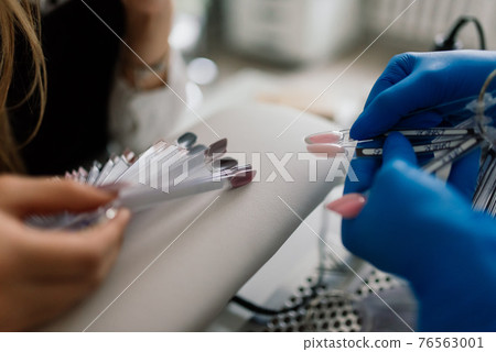 Manicure and pedicure salon, covid-19 and social distance. Master in rubber gloves and woman client Manicure and pedicure salon, covid-19 and social distance. Master in rubber gloves and woman client 76563001