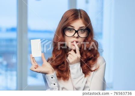 cheerful red-haired woman with a business card in her hands Office Copy Space manager cheerful red-haired woman with a business card in her hands Office Copy Space manager 76563736