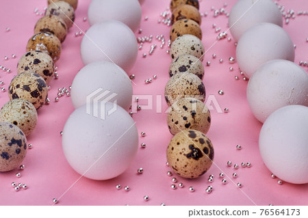 Close-up quail and chicken eggs on pink background. 76564173