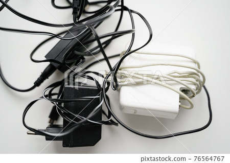 E waste, old cables and green plant. Gadget recycle of tech junk. Environment pollution E waste, old cables and green plant. Gadget recycle of tech junk. Environment pollution 76564767
