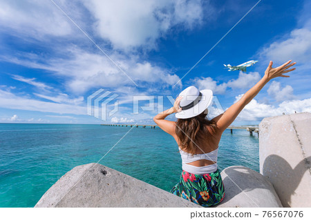 Woman waving towards the plane 76567076