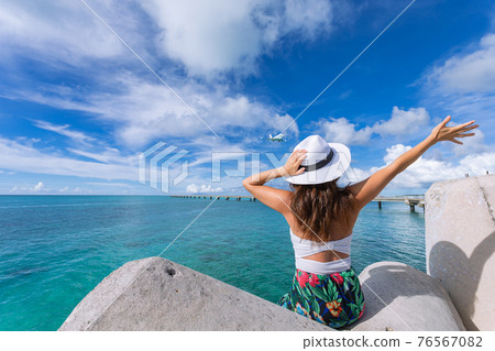 Woman waving towards the plane Woman waving towards the plane 76567082