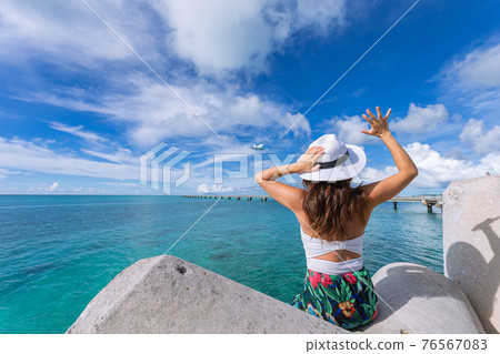 Woman waving towards the plane Woman waving towards the plane 76567083