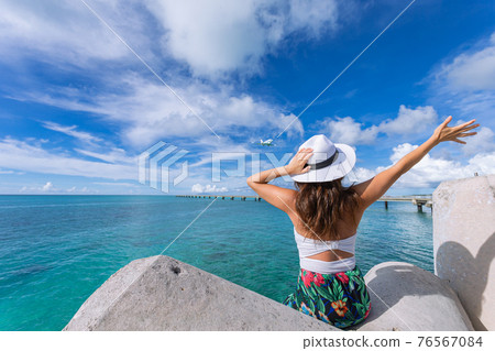 Woman waving towards the plane Woman waving towards the plane 76567084