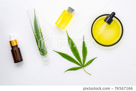 Glass bottle of cannabis oil and hemp leaves set up  on white background. 76567166