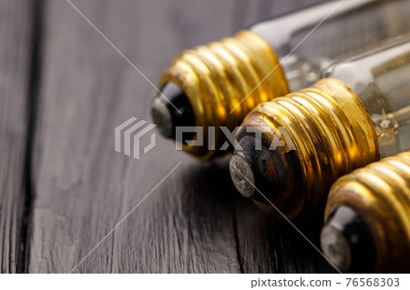 Light bulbs on dark wooden background close up 76568303