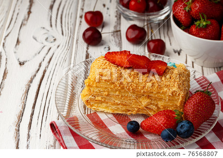 Piece of russian honey cake medovik served with berries 76568807
