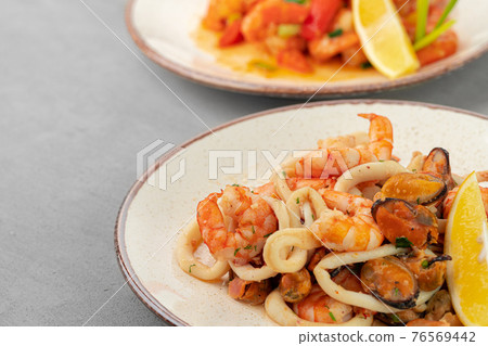 Stir fried seafood with sauce on plate with napkin Stir fried seafood with sauce on plate with napkin 76569442