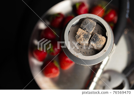 Hookah with strawberry flavour close up on dark background Hookah with strawberry flavour close up on dark background 76569470