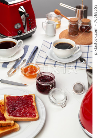 Close up photo of kitchen table with .appliances, kitchenware with toasts and jams Close up photo of kitchen table with .appliances, kitchenware with toasts and jams 76569555