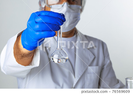 Close up of hands of a scientist working with laboratory samples 76569609