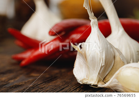 Garlic and chili pepper on dark wooden table Garlic and chili pepper on dark wooden table 76569655