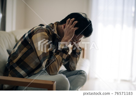Image of a man who is depressed and holds his head Image of a man who is depressed and holds his head 76571183