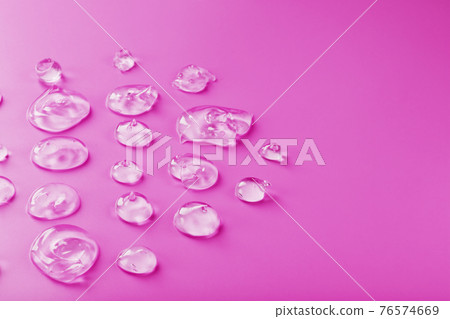 Transparent drops of Gel on a pink background with free space. 76574669