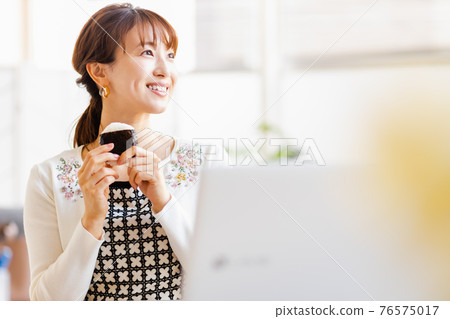 A woman eating rice balls in a bright room 76575017