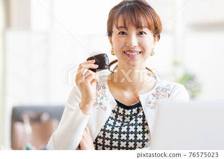 一個女人在明亮的房間裡吃飯糰 一個女人在明亮的房間裡吃飯糰 76575023