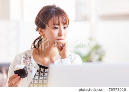 A woman eating rice balls in a bright room A woman eating rice balls in a bright room 76575026
