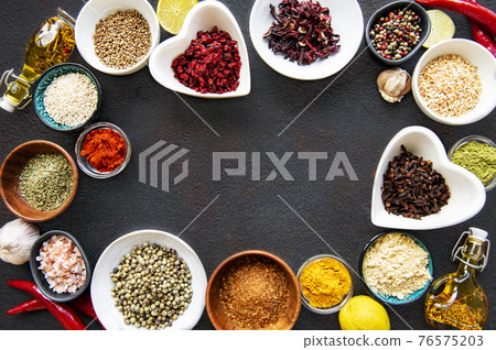 Various spices in a bowls on a black Various spices in a bowls on a black 76575203