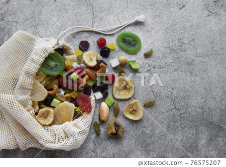 Different dried fruits and nuts in an eco bag Different dried fruits and nuts in an eco bag 76575207