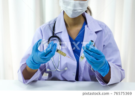 Hand holding syringe and vaccine treatment from Coronavirus covid-19 infection. 76575369