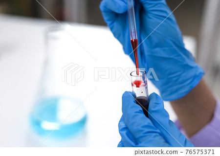 Scientist holding Coronavirus covid-19 infected blood sample tube DNA testing of the blood in the laboratory with blood sample collection tubes and syringe Coronavirus Covid-19 vaccine research. Scientist holding Coronavirus covid-19 infected blood sample tube DNA testing of the blood in the laboratory with blood sample collection tubes and syringe Coronavirus Covid-19 vaccine research. 76575371