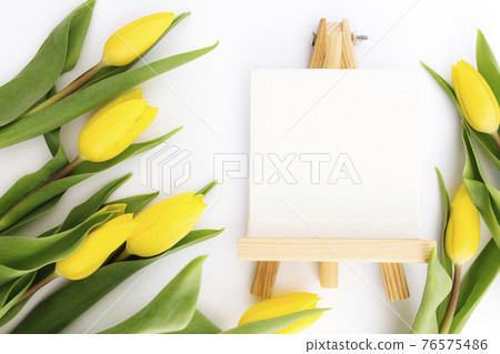 Yellow tulips flat lay on white background, empty picture frame, greeting card 76575486