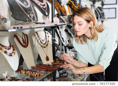 Woman looking at necklace from red chalcedony 76577300