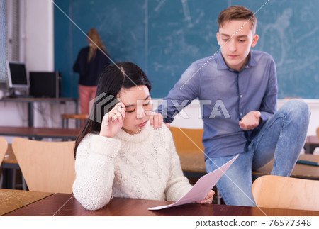 Classmate comforting upset asian girl student 76577348