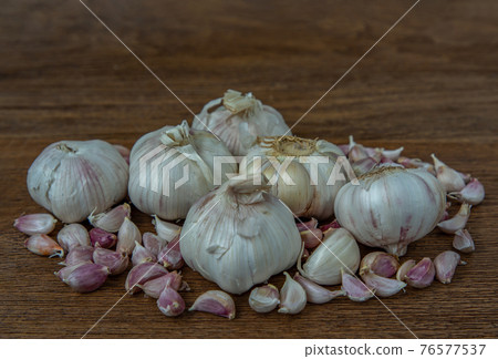 Garlic bulbs and Garlic cloves on Wooden rustic table. Garlic bulbs and Garlic cloves on Wooden rustic table. 76577537