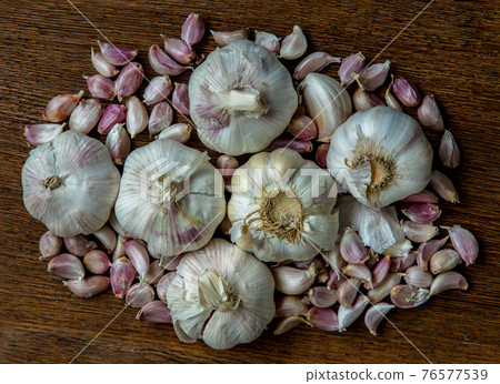 Garlic bulbs and Garlic cloves on Wooden rustic table. 76577539