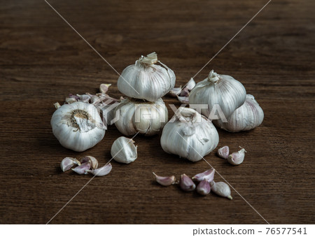 Garlic bulbs and Garlic cloves on Wooden rustic table. Garlic bulbs and Garlic cloves on Wooden rustic table. 76577541