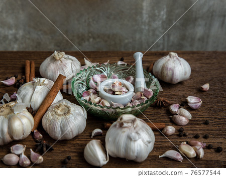 Garlic bulbs and Garlic cloves with Herbs spices, Cinnamon, Star anise and Pepper grain on Wooden rustic table. Garlic bulbs and Garlic cloves with Herbs spices, Cinnamon, Star anise and Pepper grain on Wooden rustic table. 76577544