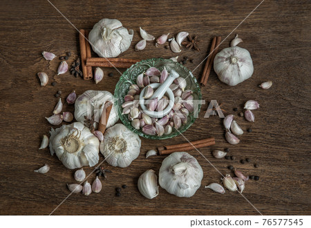 Garlic bulbs and Garlic cloves with Herbs spices, Cinnamon, Star anise and Pepper grain on Wooden rustic table. Garlic bulbs and Garlic cloves with Herbs spices, Cinnamon, Star anise and Pepper grain on Wooden rustic table. 76577545