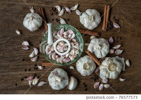 Garlic bulbs and Garlic cloves with Herbs spices, Cinnamon, Star anise and Pepper grain on Wooden rustic table. Garlic bulbs and Garlic cloves with Herbs spices, Cinnamon, Star anise and Pepper grain on Wooden rustic table. 76577573
