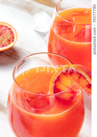 Orange cocktail close-up with blood oranges on a wooden table 76577780