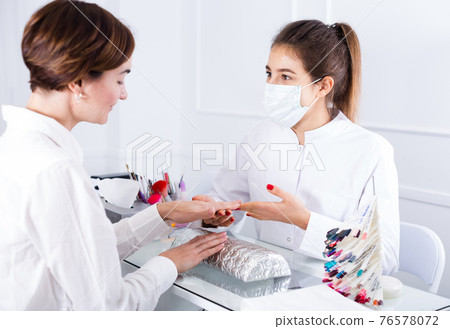 Woman doing shellac manicure 76578072