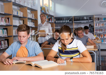 Students reading books in library Students reading books in library 76578163