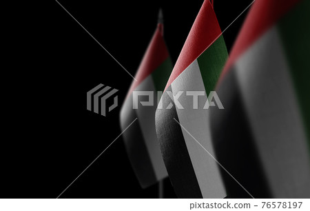 Small national flags of the United Arab Emirates on a black background 76578197